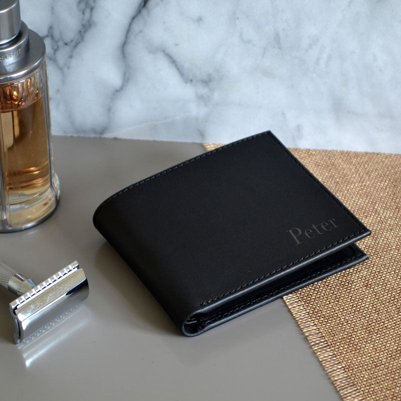 A personalised black wallet with the name "Peter" engraved on the leather front. 